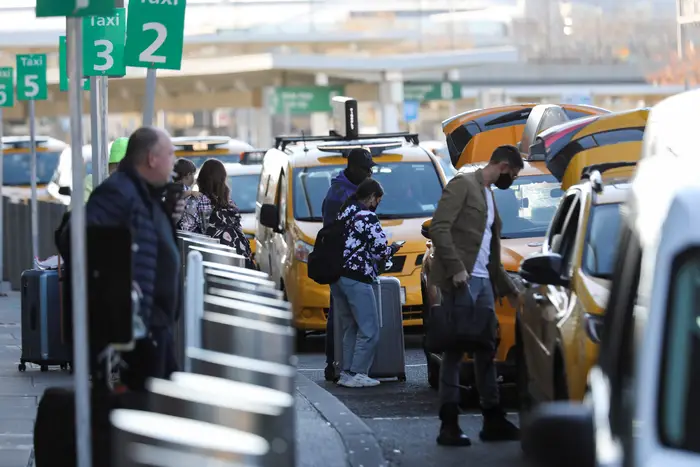 Travelers wait in a taxi cab stand at JFK Airport in New York City.